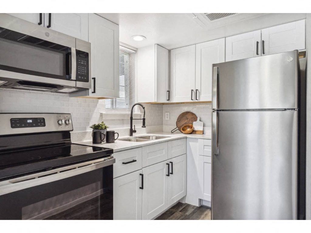 a kitchen with stainless steel appliances and white cabinets