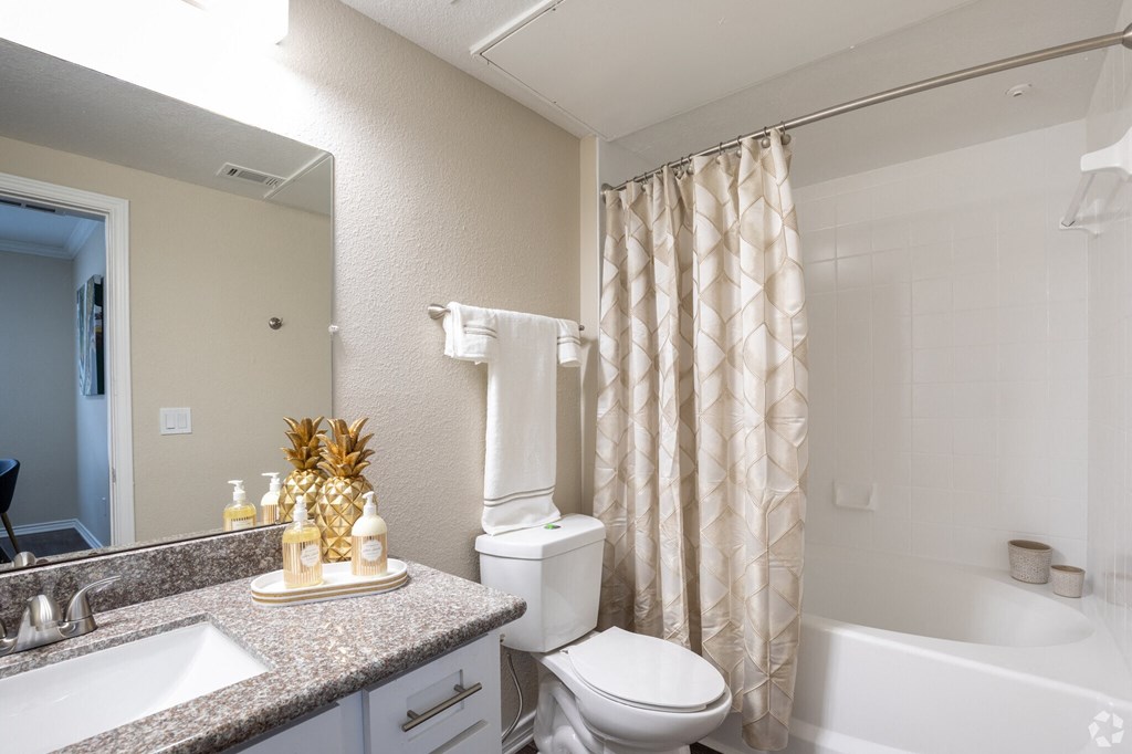A bathroom with a toilet, sink, and bathtub.