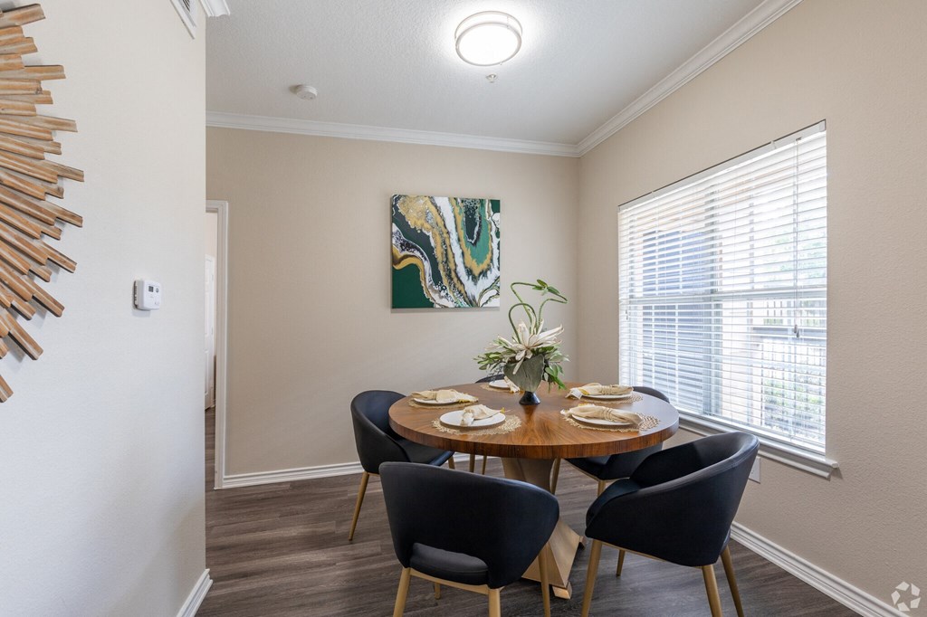 A dining room with a round table set for four.