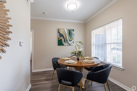 A dining room with a round table set for four.