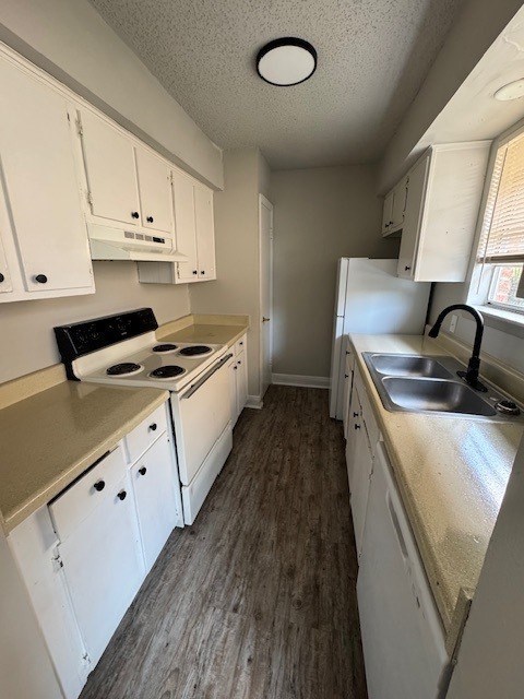 A kitchen with white cabinets and a black stove top.