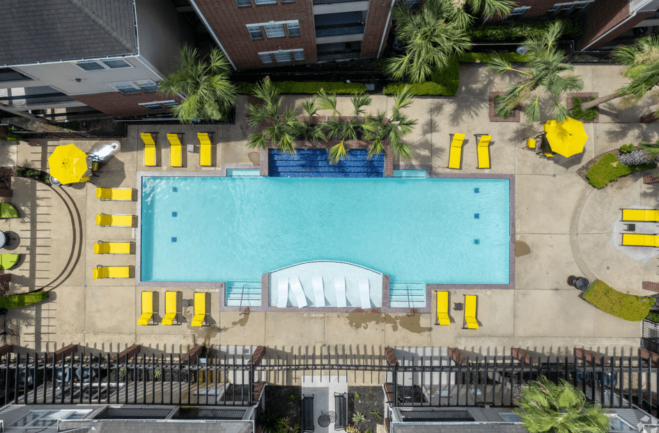 A large swimming pool surrounded by yellow lounge chairs.