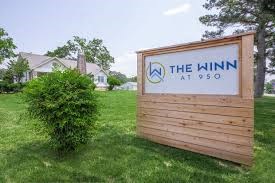 the sign for the inn on the grass in front of a house