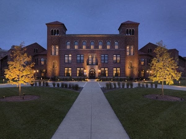 a large brick building with a sidewalk in front of it