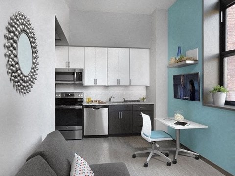 a small kitchen with a desk and a chair
