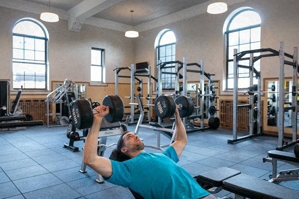a man exercising in a gym with weights