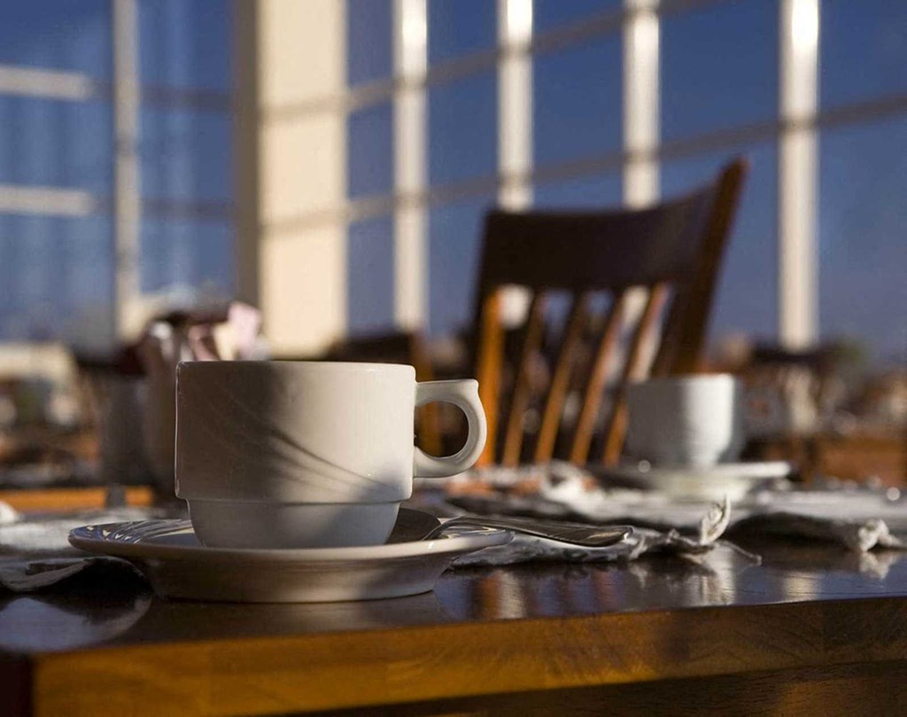 a coffee cup sitting on a table with a chair