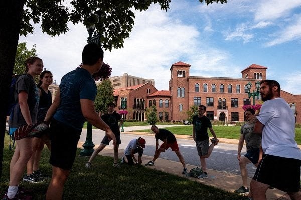 a group of people standing on a sidewalk in front of a building