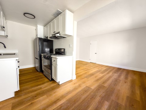 A kitchen with wooden floors and white walls.
