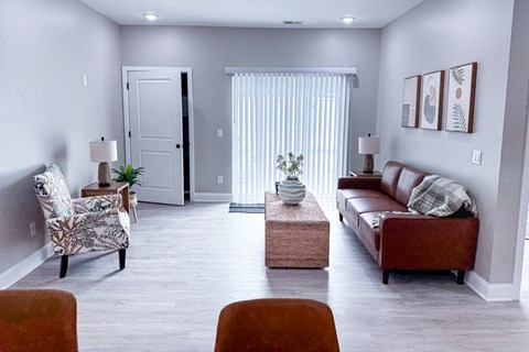 A living room with a brown couch, a chair, and a coffee table.