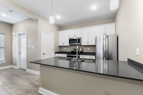 a kitchen with a large island and a stainless steel refrigerator