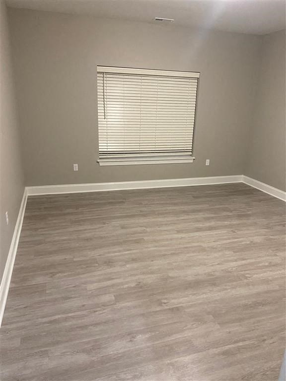 an empty room with wooden floors and a window