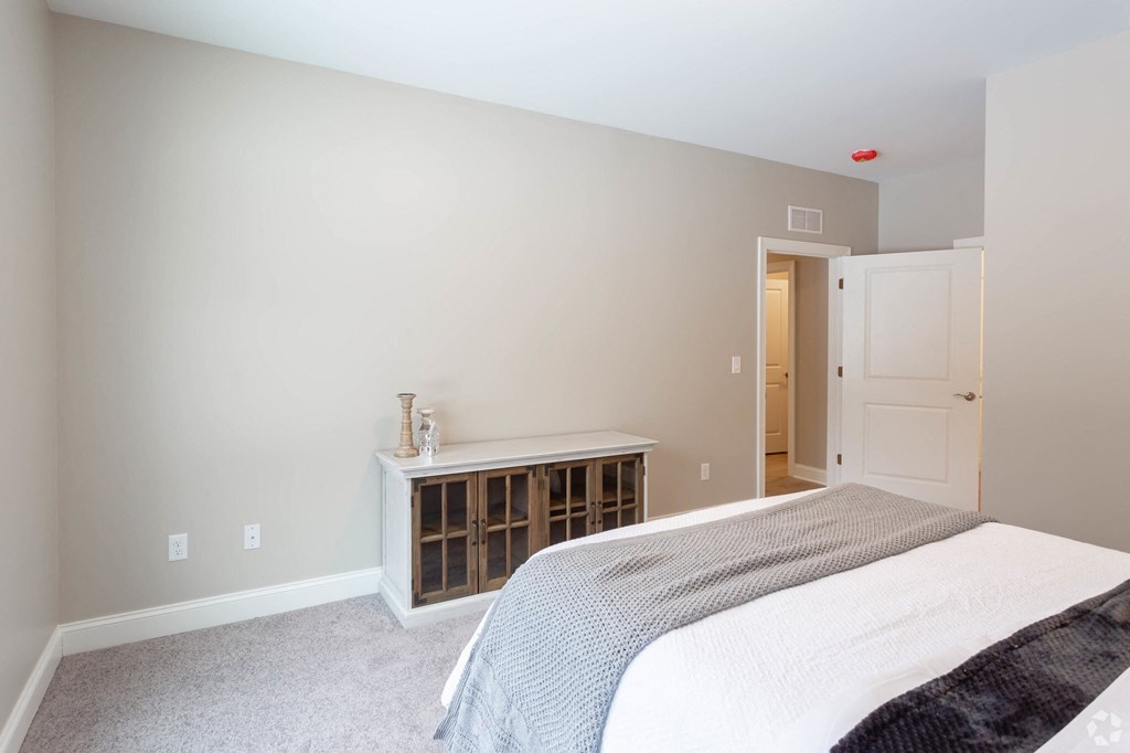 a bedroom with a bed and a closet and a door to a bathroom