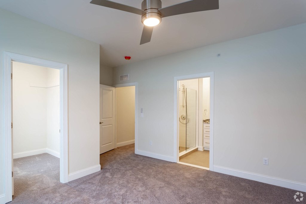an empty living room with a ceiling fan