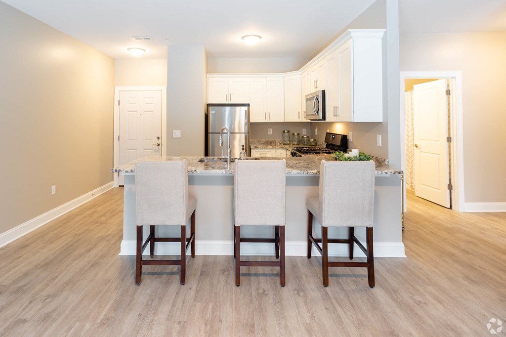 a kitchen with an island and a counter top with chairs