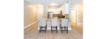 a kitchen with an island and a counter top with chairs