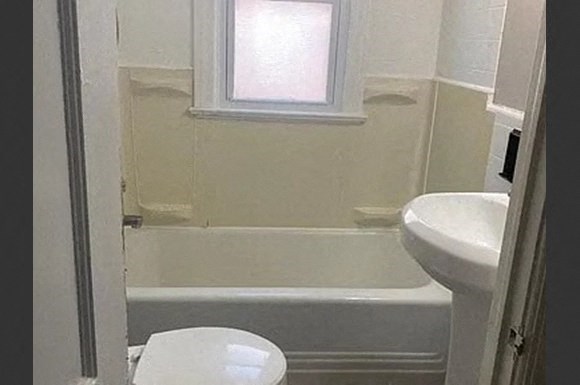 a bathroom with a toilet and a bath tub