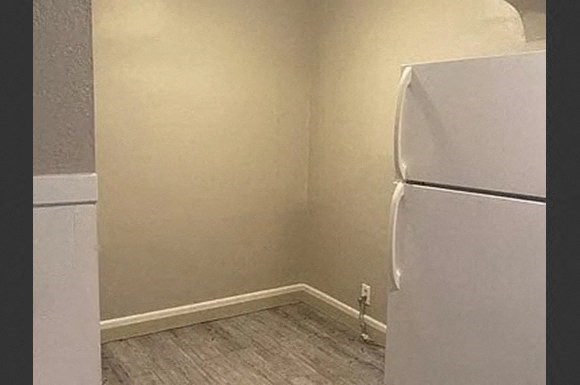 a small room with a white refrigerator in it