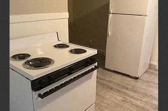 a white stove in a kitchen with a refrigerator