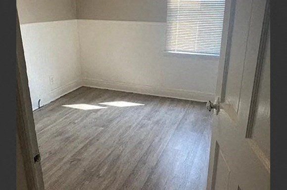 an empty room with wooden floors and a window