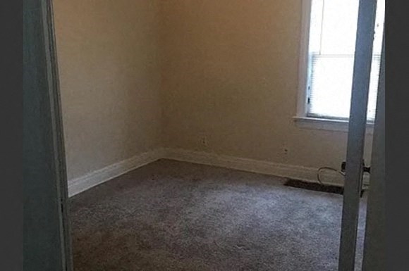 an empty room with a window and a door