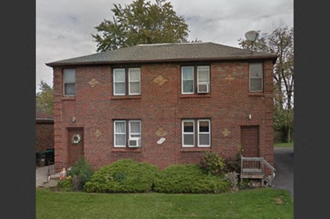 a brick house with a yard in front of it