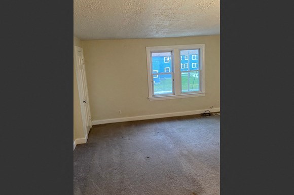 an empty living room with a window in it