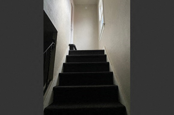 a stairwell with black stairs in a dark room