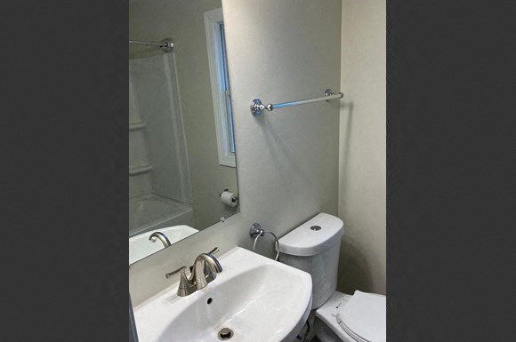 a white bathroom with a sink and a mirror