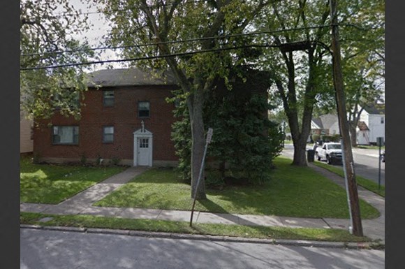 a red brick house on the corner of a street