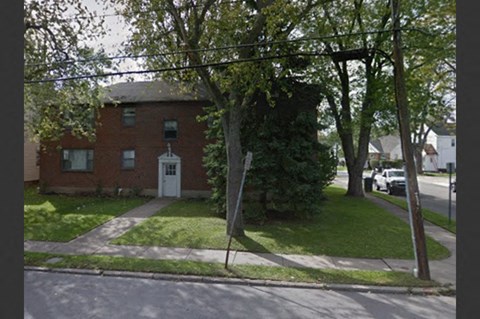 a red brick house on the corner of a street