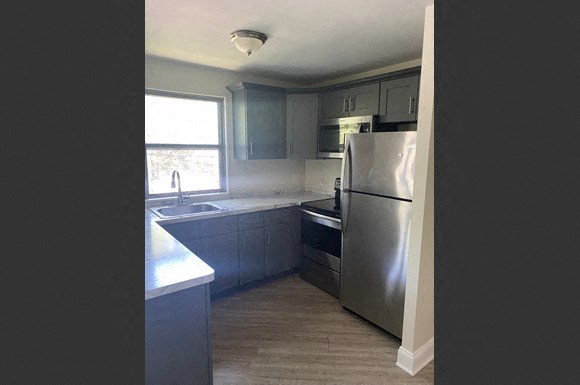 a kitchen with a stainless steel refrigerator and a sink