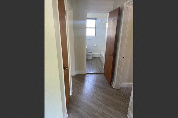 a hallway with a door open to a bathroom
