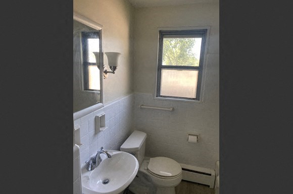 a bathroom with a toilet and a sink and a window