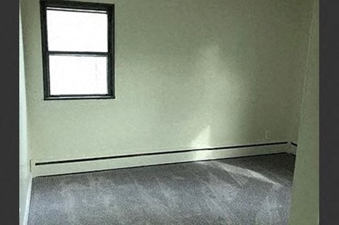 an empty room with a window on the wall