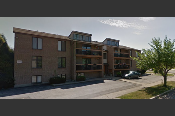 a large apartment building with a car parked in front