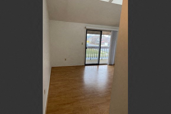 a empty living room with a door to a balcony