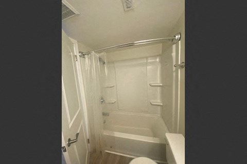 a small white bathroom with a shower and a toilet