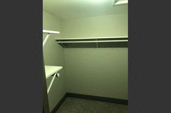 a small room with a closet and a shelf