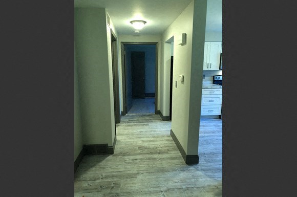 a long hallway with a view of a kitchen and