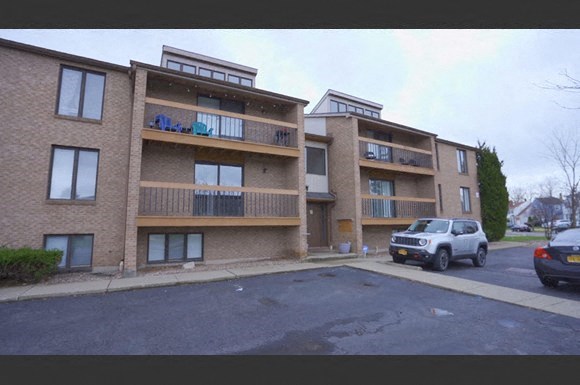 a car parked in front of an apartment building