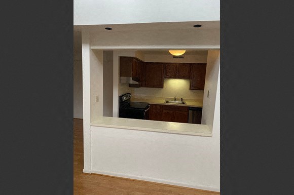 a view of a kitchen from a gap in the wall