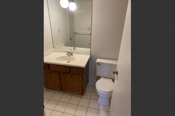 a bathroom with a toilet sink and a mirror