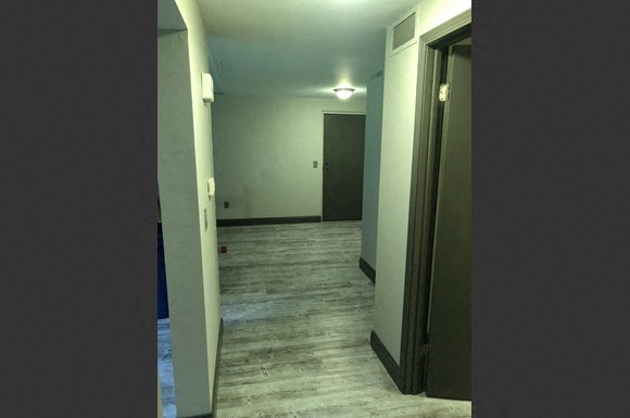 a empty room with a door open and a hallway