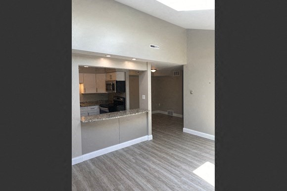 an empty living room with a kitchen in it