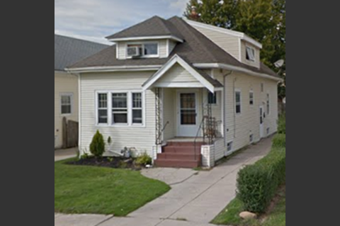 a white house with a sidewalk in front of it