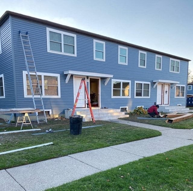 a blue house with a man working on the front of it