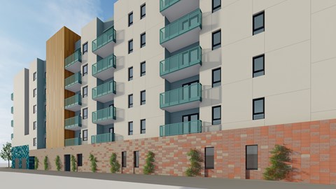 A modern apartment building with balconies and a brick wall in front.