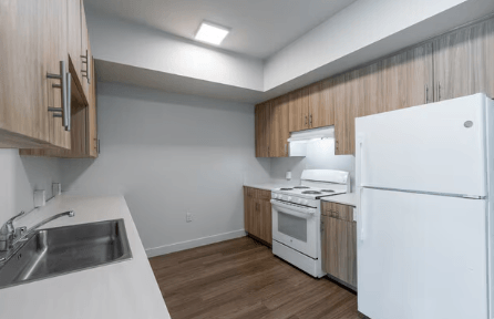 A kitchen with white appliances and wooden cabinets.