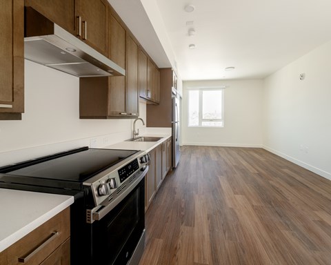 A kitchen with wooden floors and a stove top oven.
